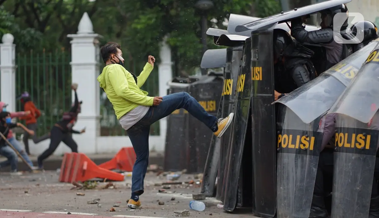 Pengunjuk rasa terlibat bentrok dengan polisi di Jalan Medan Merdeka Timur, Jakarta, Kamis (8/10/2020). Bentrokan terjadi akibat massa yang memaksa masuk ke depan Istana Negara untuk berunjuk rasa terkait penolakan UU Cipta Kerja. (Liputan6.com/Immanuel Antonius)