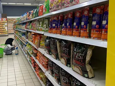 Seorang pelanggan melihat produk beras impor di supermarket di Kuala Lumpur, Malaysia, Selasa (3/10/2023). Pemerintah Malaysia telah meyakinkan negaranya bahwa tersedia cukup beras dan mendesak masyarakat untuk tidak menimbun beras produksi lokal setelah aksi panik pembelian baru-baru ini menyebabkan kosongnya rak-rak di supermarket dan toko kelontong di seluruh negeri. (AP Photo/Syawalludin Zain)