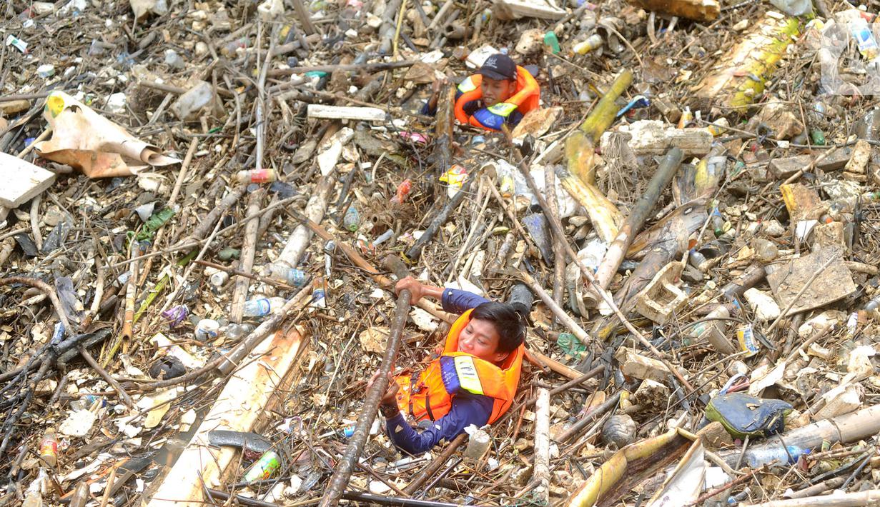 Petugas gabungan membersihkan tumpukan sampah yang menyumbat aliran air Sungai Cikeas di kawasan Bendung Koja Jatiasih, Bekasi, Jawa Barat, Rabu (16/10/2019). Pembersihan sekitar 1.200 meter kubik sampah bambu tersebut diperkirakan menghabiskan waktu dua minggu. (merdeka.com/Arie Basuki)
