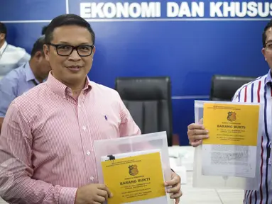 Direktur Tipideksus Brigjen Agung Setya (kiri) menunjukan barang bukti saat rilis pelaku pembobol 7 Bank dengan total kerugian sekitar Rp 1 triliun di Bareskrim Polri, Jakarta, Kamis (9/3). (Liputan6.com/Faizal Fanani)