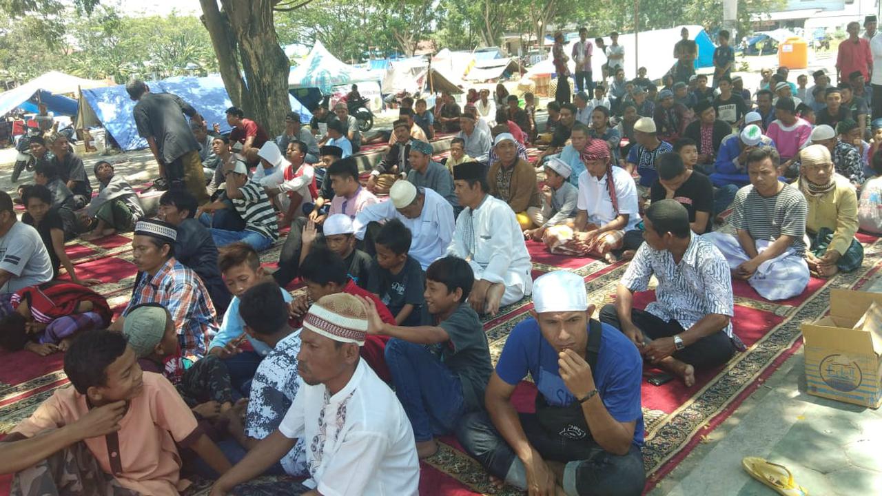 Ratusan warga Palu, Sulawesi Tengah yang menjadi korban gempa dan tsunami melaksanakan salat Jumat