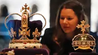 Seorang wanita melihat mahkota St. Edward dan Orb yang dipamerkan di Galeri The Queen's Diamond Jubilee di Westminster Abbey, London (29/5). (AP / Frank Augstein)