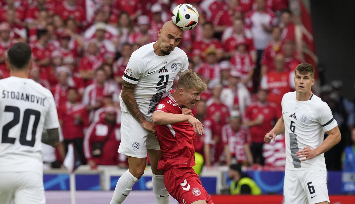 Bek Timnas Slovenia, Vanja Drkusic (atas) menyundul bola dari ancaman striker Timnas Denmark, Rasmus Hojlund pada laga Grup C Euro 2024 di MHPArena, Stuttgart, Jerman, Minggu (16/6/2024). (AP Photo/Antonio Calanni)