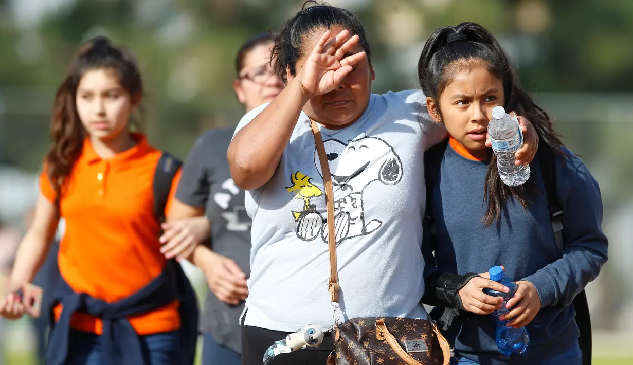 Wali murid menjemput anak mereka setelah peristiwa penembakan di sekolah menengah Salvador Castro, Los Angeles, Kamis (1/2). Sekolah ini memiliki sekitar 365 siswa dan banyak yang berasal dari keluarga berpenghasilan rendah. (AP/Damian Dovarganes)