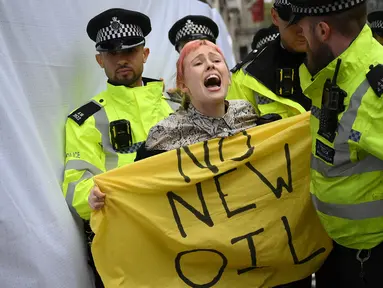 Petugas polisi memindahkan seorang aktivis iklim yang memprotes proyek ladang minyak Rosebank di Laut Utara lepas pantai Skotlandia, di luar InterContinental London Park Lane, London, 18 Oktober 2023. 18 Oktober 2023. (Daniel LEAL/AFP)