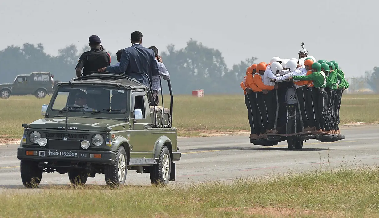 Aksi anggota Tornado dari Army Service Corps (ASC) membawa 58 orang dengan satu motor 500 cc di Bangalore (19/11). Tim Tornado memecahkan rekor sebelumnya dari 56 pria yang dimenangkan Army Signal Corps (Daredevils) pada 2010. (AFP Photo/Manjunath Kiran)