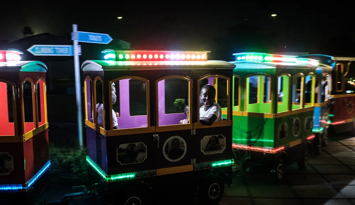 Keluarga menaiki kereta listrik di Pleasure Park di Port Harcourt, Nigeria selatan ( 14/2). Ini akan menjadi pemilu keenam yang diadakan Nigeria sejak transisi dari militer ke pemerintahan demokratis sipil pada tahun 1999. (AFP Photo/Yasuyoshi Chiba)