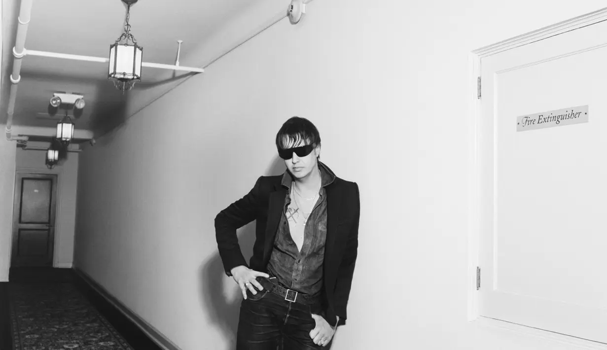 Tampil layaknya bad boy, Julian Casablancas kenakan Unbottoned shirt, jeans, dan boots [Celine]