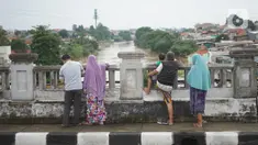 Sejumlah warga mengamati banjir yang menggenangi kawasan Rawajati dari atas flyover di Jakarta Timur, Rabu (1/1/2020). Banjir yang berasal dari luapan Sungai Ciliwung itu menjadi daya tarik tersendiri bagi sebagian pemotor yang melintasi di flyover tersebut. (Liputan6.com/Immanuel Antonius)