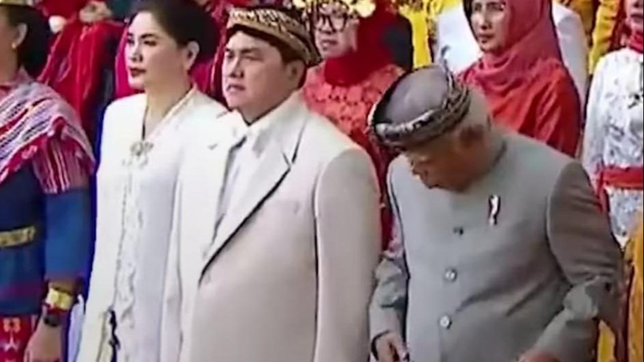Erick yang sedang serius mengikuti upacara hanya bisa tersenyum sambil mengusap beskapnya usai dijahili Basuki.
