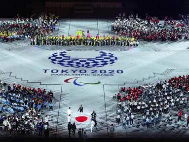 Bendera nasional Jepang dibawa ke dalam stadion oleh Motoki Iwakiri (Atletik), Tomoki Sato (Atletik), Miyuki Yamada (Renang), Sakura Koike (Renang), Kazuyasu Minobe (Anggar) dan Keiko Yamamoto (perawat) selama penutupan Paralimpiade Tokyo 2020 di Tokyo, Jepang (5/9/2021). (Joe Toth for OIS via AP)