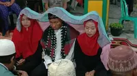 Foto mempelai pria diapit dua mempelai wanita sekaligus yang viral di media sosial FB dan diunggah oleh akun Ani Melani (Ika Aura). (foto: Liputan6.com/FB-Ani Melani/edhie prayitno ige)