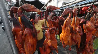 Pedagang menyiapkan babi panggang untuk perayaan Tahun Baru Imlek di Phnom Penh, Kamboja, Jumat (24/1/2020). Babi panggang menjadi menu santapan wajib bagi warga Tionghoa yang merayakan Imlek. (AP photo/Heng Sinith)