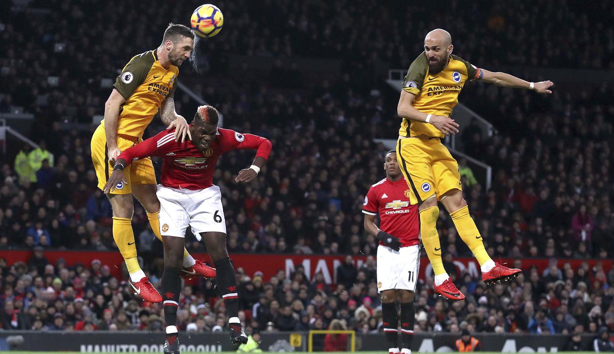 Duel pemain Brighton & Hove Albion, Shane Duffy (kiri) dan pemain Manchester United, Paul Pogba pada lanjutan Premier League di Old Trafford, Manchester,(25/11/2017). Manchester United menang tipis 1-0. (Martin Rickett/PA via AP)