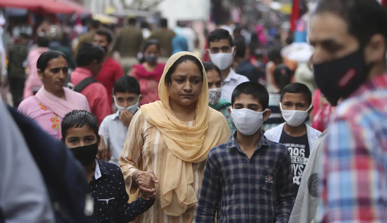 Warga India yang mengenakan masker berbelanja di Sunday market di Jammu, India, Minggu (21/3/2021). India sedang menghadapi gelombang baru infeksi Covid-19 dan mencatat rekor lonjakan harian tertinggi dalam hampir empat bulan terakhir. (AP Photo/Channi Anand)