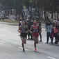 Pelari maraton Jepang, Hiroto Inoue bersaing dengan Elhassan Elabbassi dari Bahrain saat memasuki garis finis lomba Asian Games 2018 di jalan Sudirman, Jakarta, Sabtu (25/8). Hiroto menjadi pemenang lari maraton 42 kilometer. (Merdeka.com/Imam Buhori)