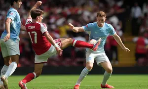 Pemain Arsenal Christos Tzolis (tengah) dan pemain Manchester City Elliot Anderson (kanan) berebut bola dalam laga final FA Community Shield antara Arsenal vs Manchester City di Cardiff, Wales, Minggu, 16 Agustus 2026. (AP Photo/Alastair Grant)