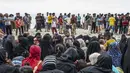 Pengungsi Rohingya duduk bersama di tanah setelah mereka tiba dengan perahu di Pantai Kalee, Laweung, Kabupaten Pidie, Provinsi Aceh, Indonesia, Selasa (14/11/2023). Hampir 200 pengungsi Rohingya, termasuk banyak perempuan dan anak-anak, terdampar di provinsi paling barat Indonesia pada 14 November, menurut laporan setempat. (Jon S./AFP)