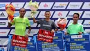 Pelari Indonesia, Asmara Bara (tengah) mengangkat tangan usa imenerima hadiah lombalari Jakarta Marathon 2015 di Silang Monas Jakarta, Minggu (25/10/2015). Bara mencatat waktu dua jam 32 menit. (Liputan6.com/Helmi Fithriansyah)