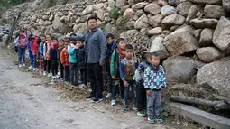 Sejumlah anak berbaris menuju sekolah mereka Desa Atuleer, Tiongkok, Rabu (19/11). Sebelum ada tangga baru, anak-anak harus menempuh perjalanan selama 2 jam menuju ke sekolah yang berada di kaki gunung. (REUTERS)