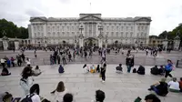Turis berdiri di depan Istana Buckingham di London, Kamis (8/9/2022). Istana Buckingham mengatakan Ratu Elizabeth II telah ditempatkan di bawah pengawasan medis karena dokter "memperhatikan kesehatan Yang Mulia." Anggota keluarga kerajaan pergi ke Skotlandia untuk bersama raja berusia 96 tahun itu. (AP Photo/Frank Augstein)