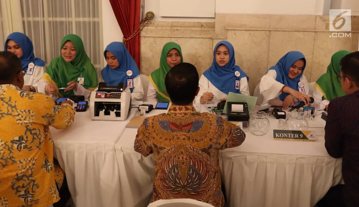 Petugas melayani pembayaran zakat di Istana Negara, Jakarta, Senin (28/5). Sekitar 300 pejabat kementerian/lembaga tinggi negara dan direksi BUMN melakukan pembayaran zakat melalui Baznas . (Liputan6.com/Angga Yuniar)
