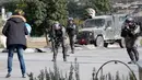 Pasukan keamanan Israel bersiap menembak pria Palestina setelah dia menikam seorang tentara di kota al-Bireh, Tepi Barat yang diduduki Israel (15/12). Pria tersebut membawa pisau dan diduga memegangi benda diduga bom. (AFP Photo/Oren Ziv)