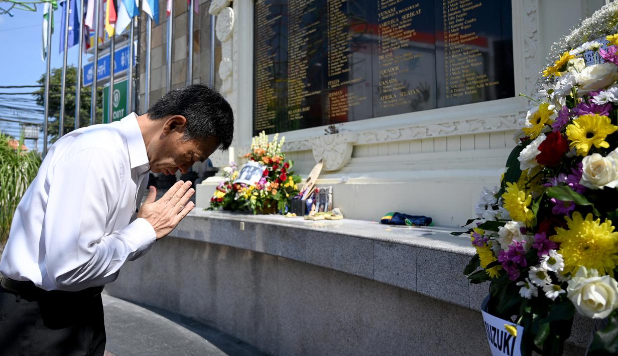 Pejabat konsulat Jepang berdoa di Monumen Bom Bali, Kuta, dekat Denpasar pada Sabtu (12/10/2019). MeMperingati 18 tahun peristiwa bom Bali yang terjadi pada 12 Oktober 2002, wisatawan dan kerabat korban mengunjungi tugu peringatan untuk berdoa dan tabur bunga. (SONNY TUMBELAKA / AFP)