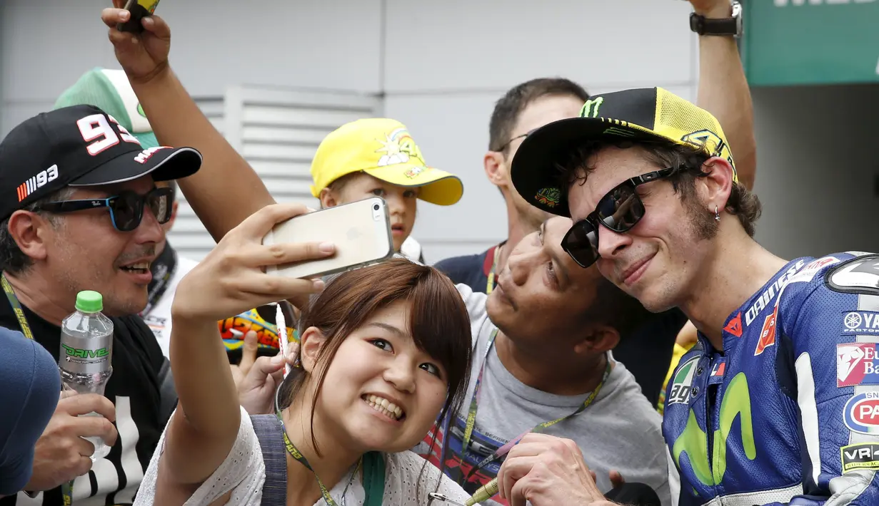 Valentino Rossi berfoto bersama penggemarnya setelah latihan bebas GP Malaysia di Sirkuit Sepang, Malaysia, (23/10/2015). (Reuters/Olivia Harris)
