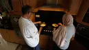 Hasan Titi (56) membantu istrinya, Samar Titi memasak hidangan di dapur rumah mereka di Kota Nablus, Tepi Barat, 30 Maret 2020. Di Palestina, para perempuan yang biasanya melakukan pekerjaan memasak, namun kondisi itu berubah di tengah penerapan karantina wilayah (lockdown). (Xinhua/Ayman Nobani)