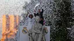 Bek Real Madrid Sergio Ramos dan Marcelo mengangkat trofi Liga Champions di dekat patung Cibeles saat merayakan kemenangan setelah meraih gelar ke-12 di Madrid, Spanyol (4/6). (AP Photo / Paul White)