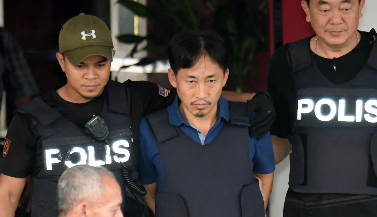 WN Korut Ri Jong Chol dikawal dua anggota polisi meninggalkan markas Polisi Sepang, Malaysia, Jumat (3/3). Kurangnya bukti terkait pembunuhan terhadap Kim Jong-nam, Malaysia resmi membebaskan Ri Jong Chol dari tahanan. (Muneyoshi Someya/Kyodo News via AP)