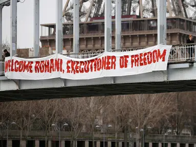 Seorang aktivis dari organisasi hak-hak perempuan Femen melakukan aksi bergelantungan dari sebuah jembatan di Paris, Prancis, Kamis (28/1). Ia menggelar protes atas kunjungan Presiden Iran, Hassan Rouhani ke Paris. (REUTERS/Charles Platiau)