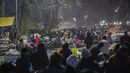 Pembeli berkerumun untuk membeli pakaian hangat di pasar terbuka pada hari yang dingin di Srinagar, Kashmir yang dikuasai India, Minggu (26/12/2021). (AP Photo/Mukhtar Khan)