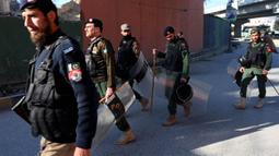 Polisi berpatroli di sepanjang jalan di Peshawar pada tanggal 9 Februari 2024, sehari setelah pemilihan umum nasional Pakistan. (Abdul MAJEED/AFP)