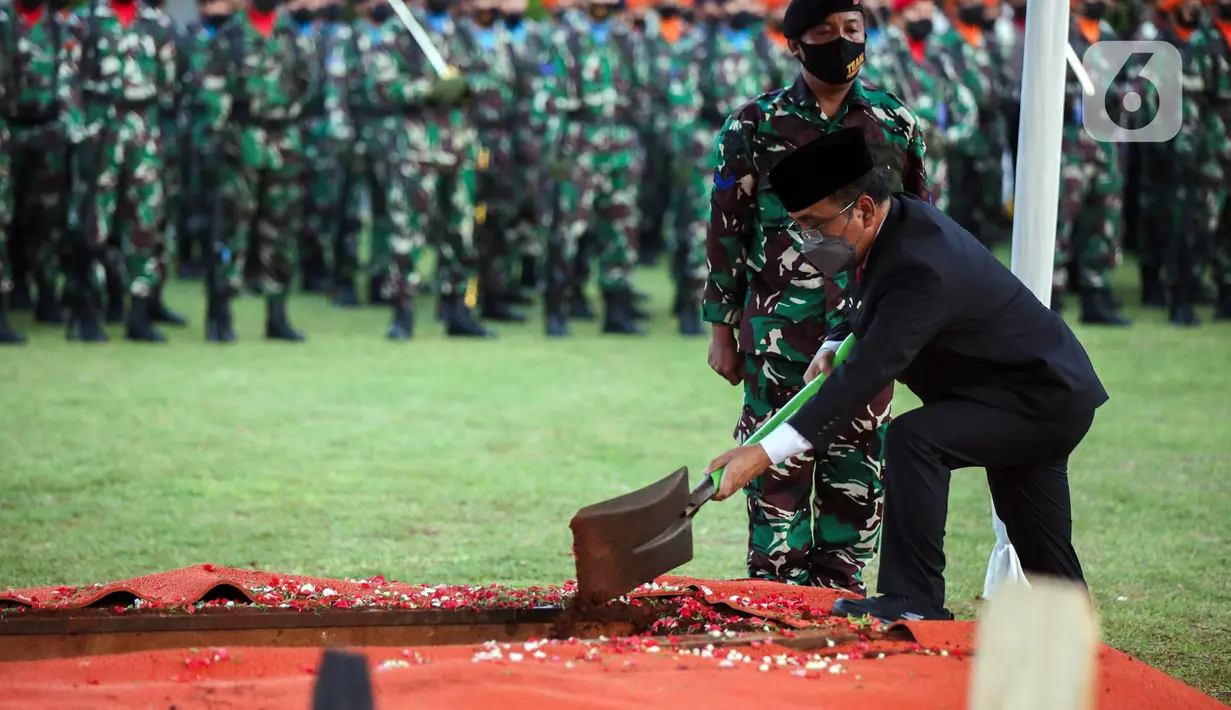 Menteri Sekretaris Negara (Mensesneg) RI Pratikno secara simbolik menguburkan jenazah Menpan RB Tjahjo Kumolo saat prosesi pemakaman di Taman Makam Pahlawan Kalibata, Jakarta, Jumat (1/7/2022). Tjahjo Kumolo meninggal dunia di Rumah Sakit Abdi Waluyo Jakarta Pusat sekitar pukul 11.10 WIB. (Liputan6.com/Faizal Fanani)