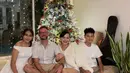 Dewi Rezer merayakan Natal bersama keluarganya yang tampil kompak serba putih. Dewi mengenakan atasan jaket berbulu dipadukan celana pendek putih, putrinya mengenakan dress off shoulder. [@rezerdewi]
