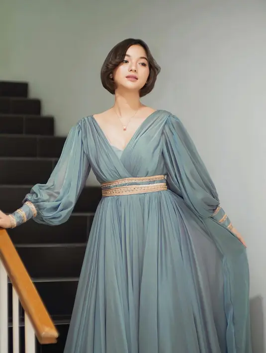 Menyalurkan gaya Cinderella dan Jasmine, Glenca memakai gaun lengan panjang warna icy blue