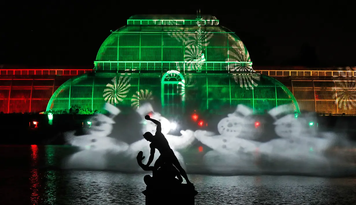 Pemandangan bangunan Kew Gardens yang dihiasi cahaya jelang perayaan Natal, Londo (21/11). Cahaya lampu yang menghiasi Kew Gardens ini menjadi daya tarik wisatawan. (AP Photo/Frank Augstein)