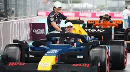 Pembalap Red Bull Racing, Max Verstappen (kanan) dan Yuki Tsunoda melakukan parede mobil lego sebelum balapan Formula 1 GP Miami 2025 yang berlangsung di Sirkuit Autodromo, Miami, Florida, Minggu (04/05/2025) waktu setempat. (AFP/Mark Thompson)