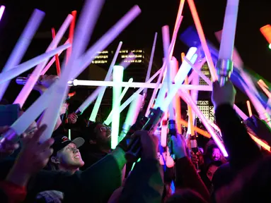 Penggemar film Star Wars berkumpul sambil membawa lightsaber (pedang sinar) saat mengikuti Glow Battle Tour di Grand Park, Los Angeles (15/12). Mereka berkumpul dengan membawa pedang sinar yang beraneka warna. (Photo by Chris Pizzello/Invision/AP)