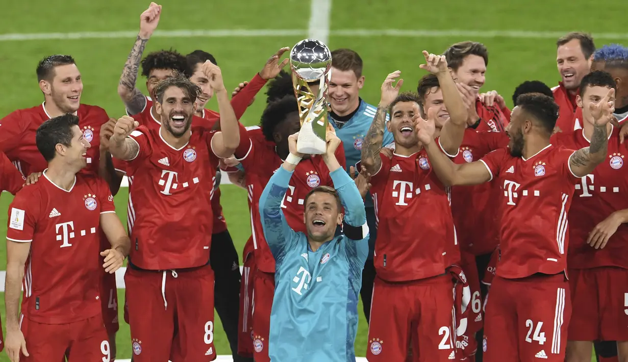 Kiper Bayern Munchen, Manuel Neuer, mengangkat trofi juara Piala Super Jerman 2020 usai mengalahkan Borussia Dortmund di Allianz Arena, Kamis (1/10/2020) dini hari WIB. Bayern Munchen menang 3-2 atas Borussia Dortmund. (Andreas Gebert/Pool via AP)