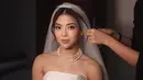 Cantiknya Clarissa dibalut gaun pengantin tanpa tali berwarna putih dengan detail mutiara yang serasi dengan kalung bertumpuk yang dikenakannya. Penampilannya semakin menarik dengan veil yang dikenakannya. [Foto: Instagram/clarissatanoe]