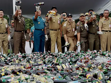 Wagub DKI Djarot Saiful Hidayat memusnahkan ribuan botol minuman beralkohol ilegal hasil operasi sejak Januari-Juni 2016, di kawasan Monas, Jakarta, Selasa (28/6). 19.628 botol yang antara lain hasil penertiban di Kalijodo. (Liptan6.com/Gempur M Surya)