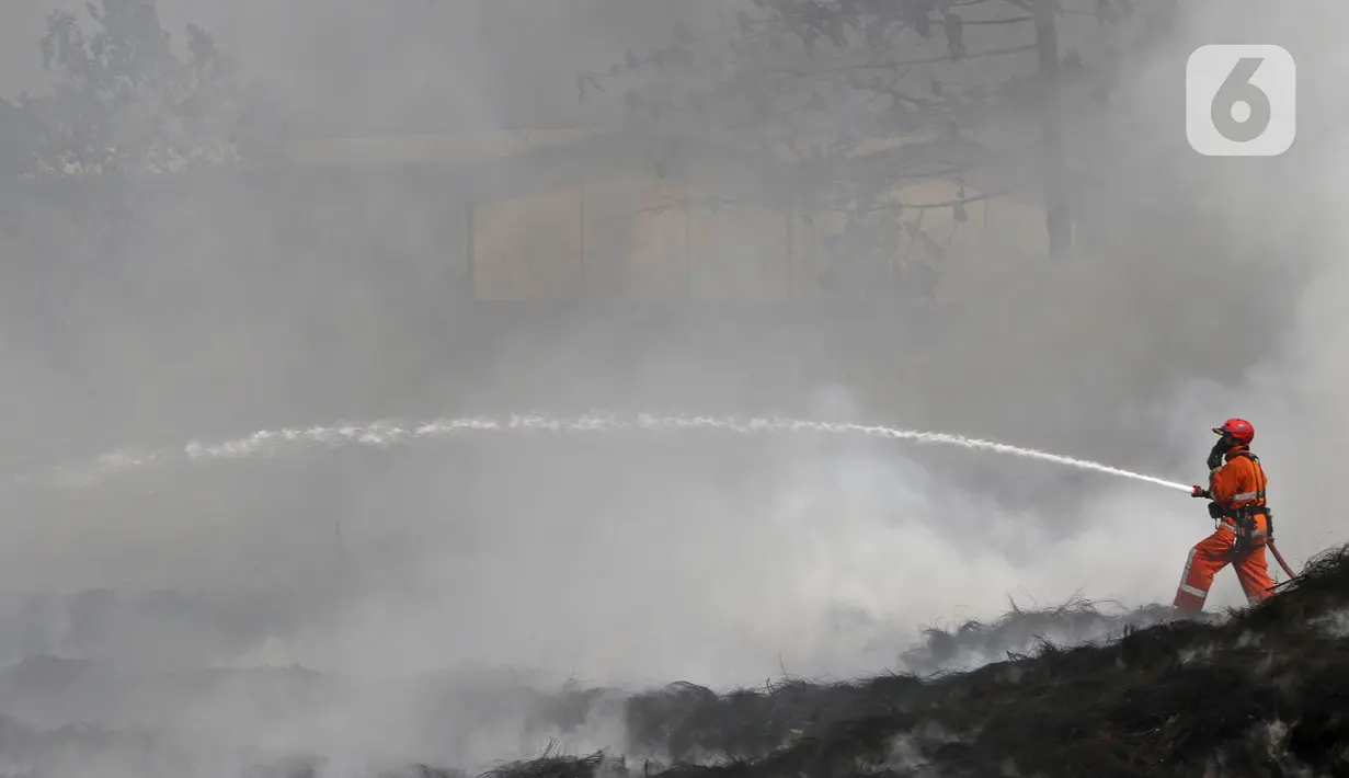 Petugas Pemadam Kebakaran Kabupaten Bogor memadamkan api di lapak ban bekas, Desa Bojong Nangka, Gunung Putri, Kamis (22/4/2021). Kebakaran lapak ban bekas yang terjadi Senin (19/4) petang tersebut hingga saat ini belum bisa dipadamkan. (Liputan6.com/Herman Zakharia)