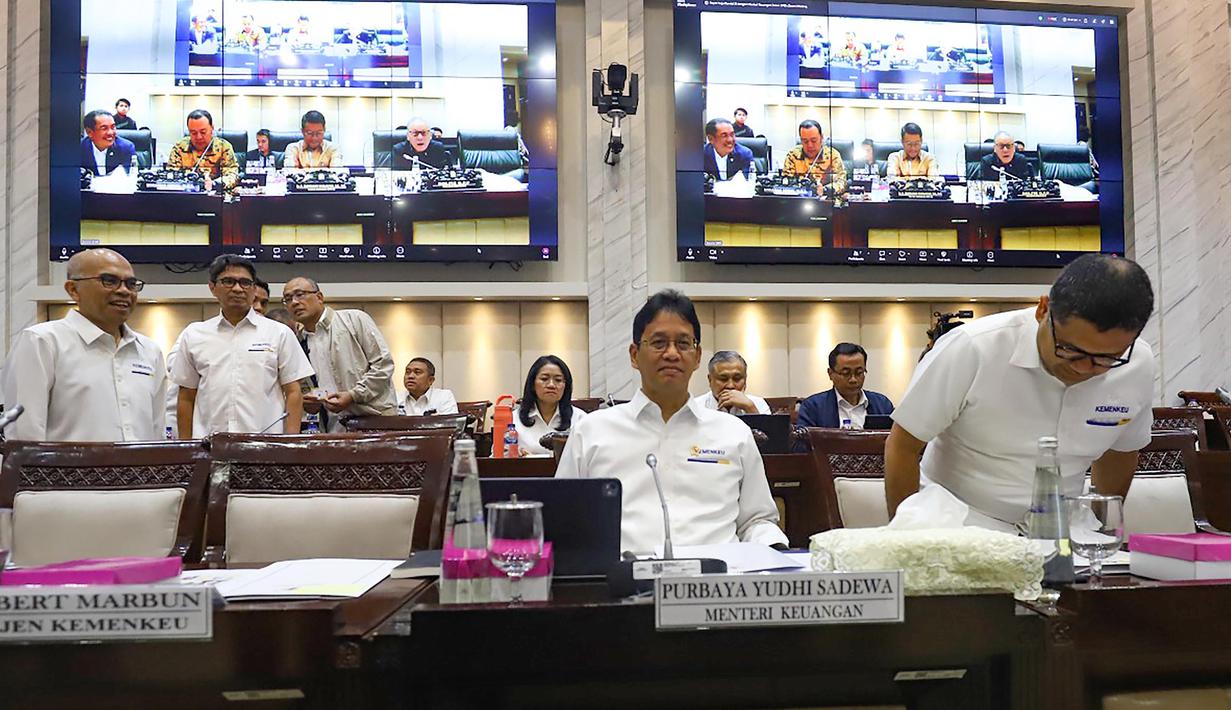 Kepastian tersebut dinyatakan Menteri Keuangan Purbaya Yudhi Sadewa saat rapat dengan Komisi XI Dewan Perwakilan Rakyat (DPR) Republik Indonesia (RI) di Kompleks Parlemen, Senayan, Jakarta, Senin (6/4/2026). Tampak dalam foto, Menteri Keuangan Purbaya Yudhi Sadewa (kedua kanan) sesaat sebelum rapat kerja bersama Komisi XI DPR di Kompleks Parlemen, Senayan, Jakarta, Senin (6/4/2026). (merdeka.com/Arie Basuki)