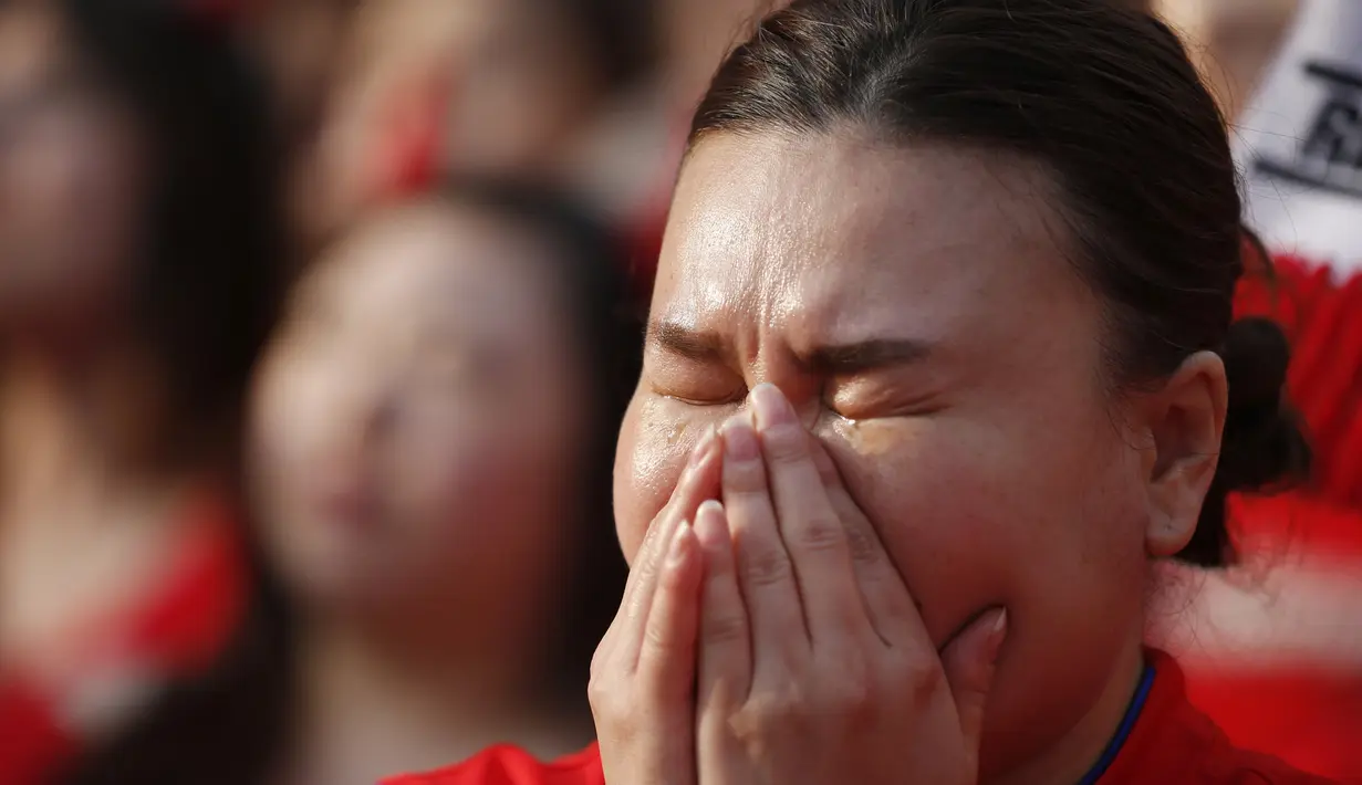 Usai dikalahkan Belgia 0-1, seorang warga tampak menangisi kekalahan timnas negaranya, Seoul, Jumat (27/6/14). (REUTERS/Kim Hong-Ji)