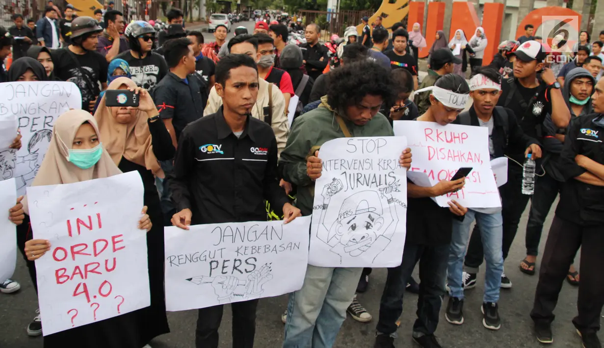 Massa yang tergabung dalam Aliansi Jurnalis Gorontalo membawa sejumlah poster saat menggelar aksi menolak RUU KUHP di Gorontalo, Senin (23/9/2019). Massa terdiri dari AJI, PWI, IJTI, dan beberapa organisasi jurnalis kampus di Gorontalo. (Liputan6.com/Arfandi Ibrahim)