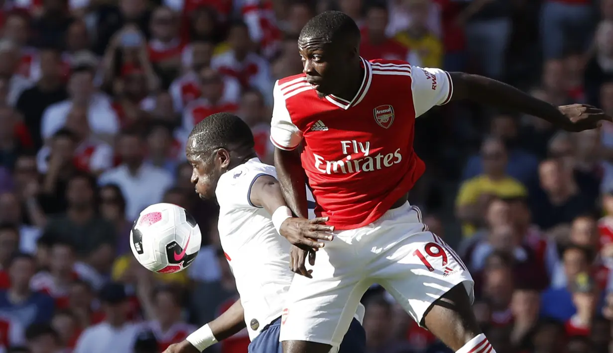 Gelandang Arsenal, Nicolas Pepe berebut bola dengan gelandang Tottenham Hotspur, Moussa Sissoko selama pertandingan Liga Inggris di stadion Emirates di London (1/9/2019). Arsenal bermain imbang 2-2 atas Tottenham. (AP Photo/Alastair Grant)