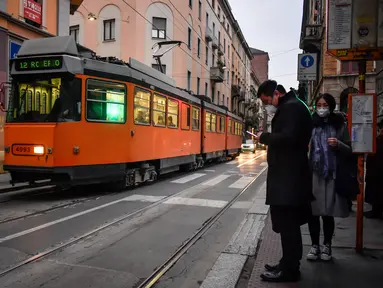 Aktivitas warga di sebuah jalan di pusat Kota Milan, Italia, Selasa (25/2/2020). Warga banyak mengurangi aktivitas di luar rumah terkait virus corona atau COVID-19 di Italia. (Claudio Furlan/LaPresse via AP)